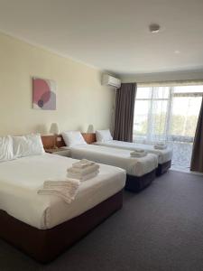 a hotel room with two beds and a window at Waterview Gosford Motor Inn in Gosford