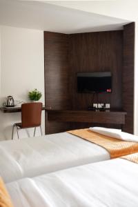 a bedroom with a bed and a tv on a wall at Catalyst Suites, Rajaji Nagar in Bangalore
