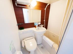 a bathroom with a toilet and a sink and a mirror at Super Hotel Akihabara Suehirocho in Tokyo