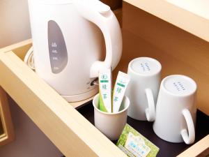 a shelf with cups and a toaster and toothbrushes at Super Hotel Akihabara Suehirocho in Tokyo