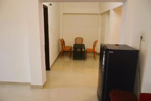 a hallway with chairs and a table and a television at Blue Beds Homestay, Exotic 2BHK AC House in Jabalpur