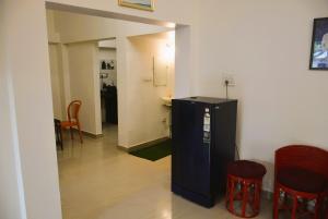 a hallway with a black refrigerator in a room at Blue Beds Homestay, Exotic 2BHK AC House in Jabalpur