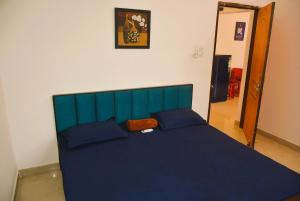 a blue bed with blue pillows in a bedroom at Blue Beds Homestay, Exotic 2BHK AC House in Jabalpur