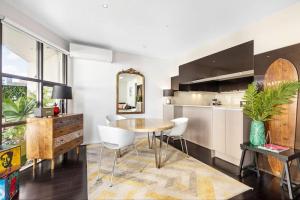 cocina con mesa, sillas y espejo en Penthouse Living Premium Location by Custom Bnb Hosting, en Melbourne