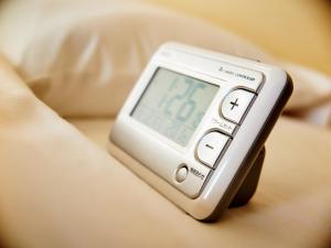 an alarm clock sitting on a bed with a clock at Super Hotel Akihabara Suehirocho in Tokyo