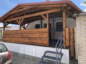 a wooden pergola on the side of a house at Búda u Kramářů - penzion Robin in Mutěnice