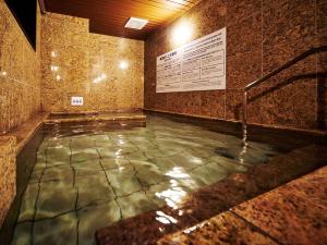 a pool of water in a room with a stone wall at Super Hotel Akihabara Suehirocho in Tokyo