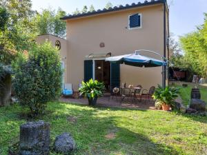 CorsanoにあるFarmhouse in Ville di corsano siena at the centreの庭のテーブルと傘を持つ家