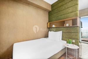 ein Schlafzimmer mit einem weißen Bett und einem Fenster in der Unterkunft Jade by Kozystay 2BR Next to Mall Kuningan in Jakarta
