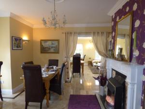 a dining room with a table and chairs and a fireplace at Parkhouse B&B in Bunratty