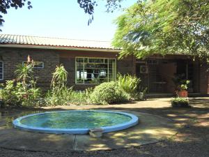 a small pool of water in front of a house at Dinizulu Cottage in Hluhluwe