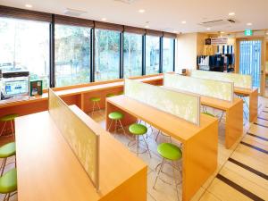 a waiting room with tables and green stools at Super Hotel Akihabara Suehirocho in Tokyo
