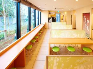 a cafeteria with green chairs and a long counter at Super Hotel Akihabara Suehirocho in Tokyo