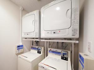 a room with two monitors and other appliances on a shelf at Super Hotel Akihabara Suehirocho in Tokyo