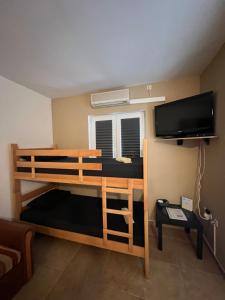 - une chambre avec des lits superposés et une télévision à écran plat dans l'établissement Apartment Dilba, à Novalja
