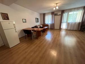 a living room with a table and a refrigerator at АПАРТАМЕНТ МАЯ с две спални in Kazanlŭk