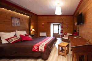ein Schlafzimmer mit einem großen Bett in einem Holzzimmer in der Unterkunft Chambres d'Hôtes Coeur de Bastié et Ranch du Lévézou in Trémouilles