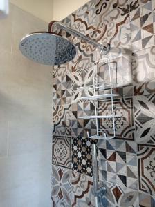 a bathroom with a shower with a tile wall at Monolocale Lucca PellegriniLittleHouse in Lucca