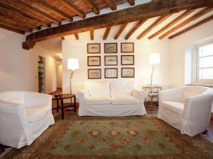 sala de estar con 2 sillas blancas y alfombra en Luxurious Apartment in Rocca Grimalda with Garden, en Rocca Grimalda