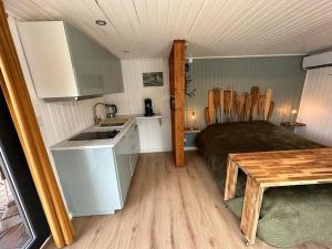 eine Küche mit einem Bett und einem Tisch in einem Zimmer in der Unterkunft Rêve sur l’eau in Moisson