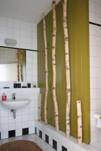 uma casa de banho com um lavatório e árvores na parede em Apartment Luk em Furth im Wald