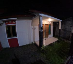 a small house at night with the door open at Bovalia Homestay Jogja in Seturan