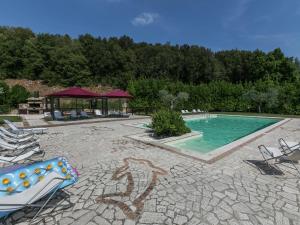 una piscina con sillas y un cenador en Elegant apartment only 1 hour from Rome, en Narni