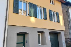 Strigno的住宿－Villa Alta，一座带绿色百叶窗和门的建筑
