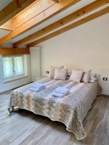 a large bed in a bedroom with wooden ceilings at Villa Alta in Strigno