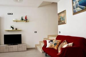 a living room with a red couch and a flat screen tv at Villa Alta in Strigno