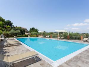 a large swimming pool with lounge chairs around it at Lavish Holiday Home in Volterra with Pool in Volterra