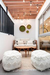 two white ottomans in a living room with a bench and a table at Stunning Modern 1BD Apartment in Barranco in Lima