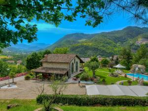 zewnętrzny widok na dom z górami w tle w obiekcie Large holiday home in Cagli with pool w mieście Acqualagna