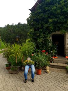 una persona agachada para mirar algunas plantas en Mühlnerhof Familie Gruber, en Aich