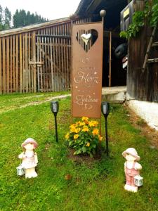 ein Schild im Gras neben zwei Hydranten in der Unterkunft Mühlnerhof Familie Gruber in Aich