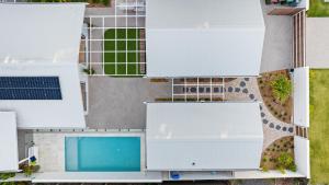 una vista aérea de una casa con piscina en Brand new coastal oasis - family & pet friendly. en Coolum Beach