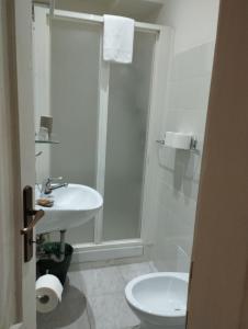 een badkamer met een douche, een wastafel en een toilet bij DormiTrieste City Life Apartment in Trieste
