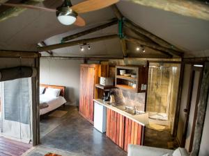 a room with a bed and a kitchen with a sink at TangleWood Nature Estate in Potchefstroom