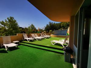 a patio with chairs and a lawn with green grass at HOTEL PARIS Relax Zone in Balchik