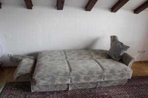 a couch sitting in a living room next to a wall at Ferienwohnung Fernsicht in Zwiefalten