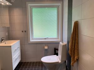 a bathroom with a toilet and a window at Le Coq Heureux in Vånga