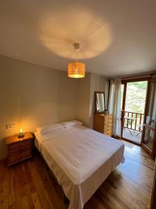 a bedroom with a large white bed and a window at Your Place Benasque in Benasque