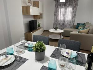 a dining table with wine glasses and a living room at Apartamento del Agua in Rute