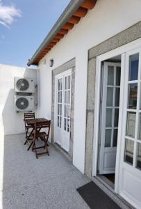 un patio con mesa y sillas junto a un edificio en OÁSIS apartments, en Viana do Castelo