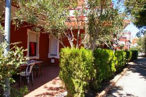 una casa con mesa, sillas y arbustos en Villaggio Magna Grecia, en Lazzaro