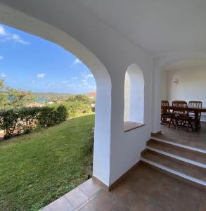 a house with a staircase and a table and chairs at Residence Gli Oleandri 140 - Costa Smeralda - Porto Cervo in Liscia di Vacca