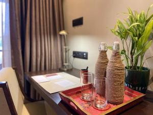 a table with two bottles and glasses on it at Miraaya Wellness and Golf Resort in Chitwan