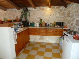 a kitchen with wooden cabinets and a checkered floor at Villa Angela, Panoramablick übers Meer in Vasilikos