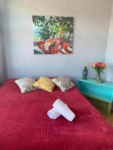 a red bed with two towels and a painting on the wall at Hostel ERA in Tbilisi City