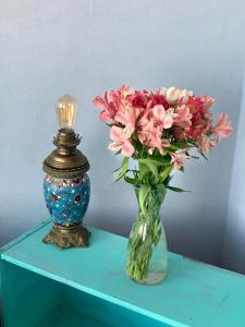 un vase de fleurs sur une table à côté d'une lampe dans l'établissement Hostel ERA, à Tbilissi